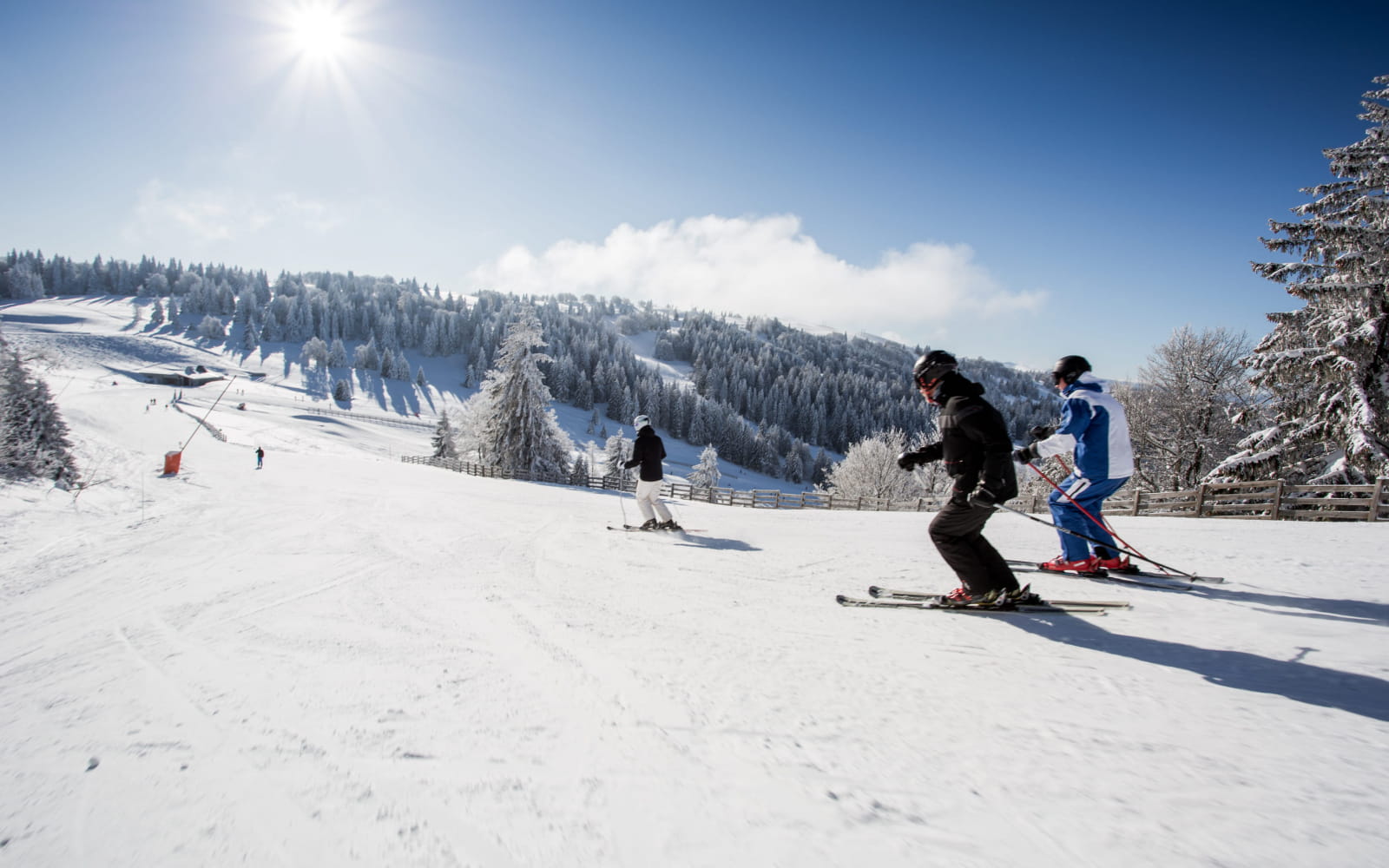 Famille qui dévale les pentes de ski alpin à Métabief