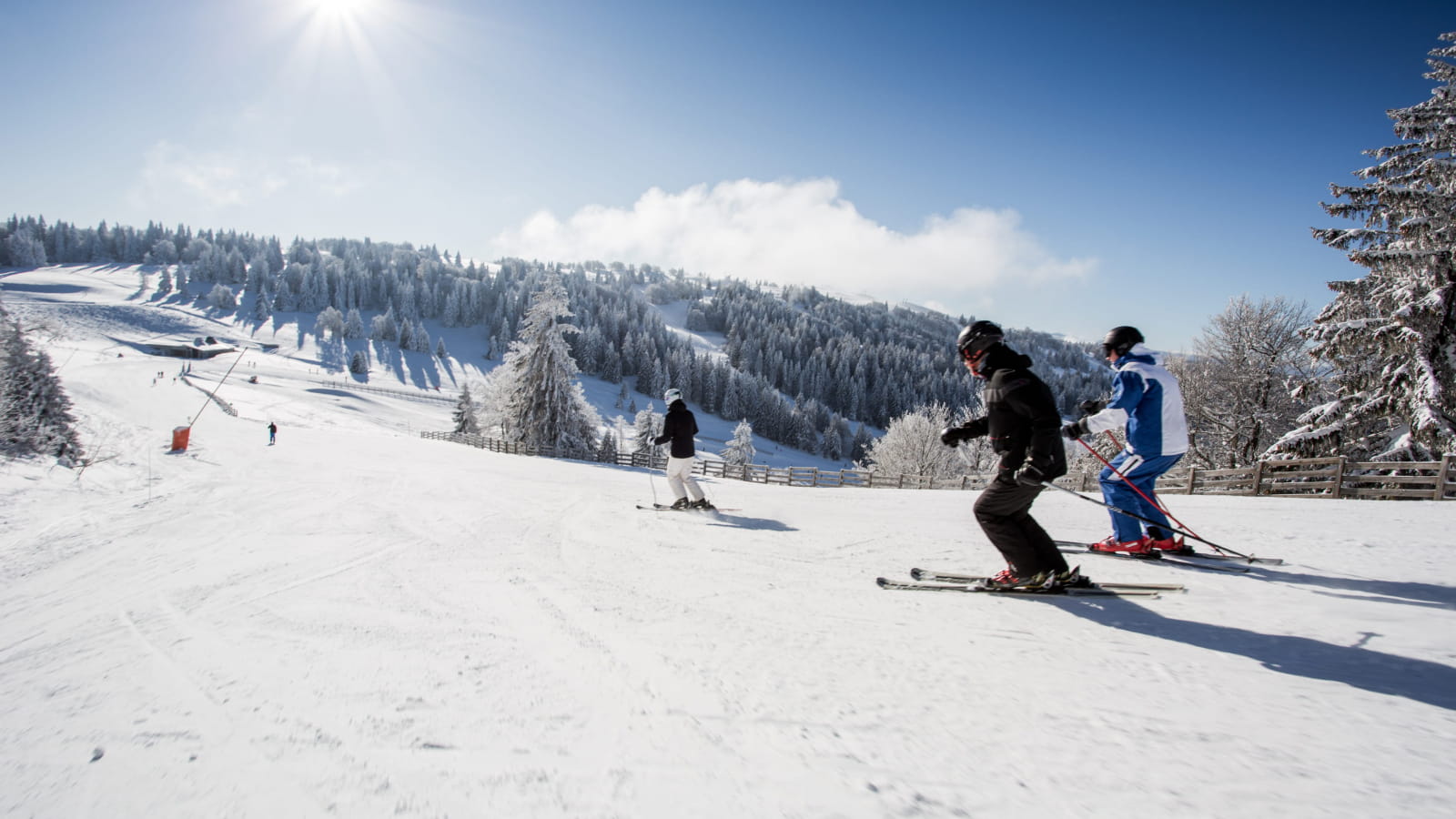 Famille qui dévale les pentes de ski alpin à Métabief