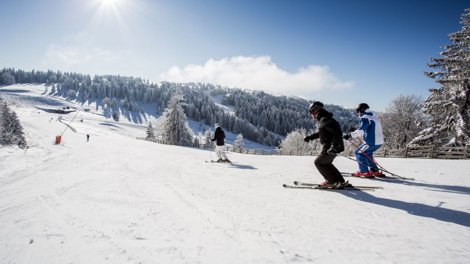 Famille qui dévale les pentes de ski alpin à Métabief