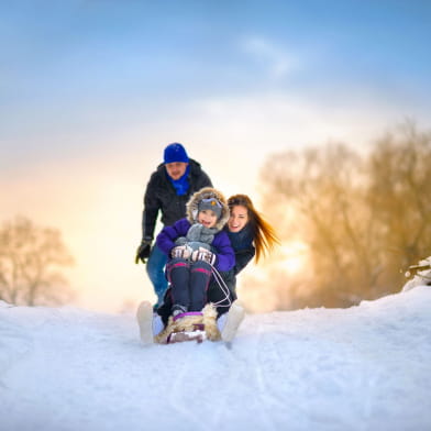 la famille heureuse fait le tour du traîneau en bois d'hiver, des animations d'hiver gaies, tout est recouvert de neige
