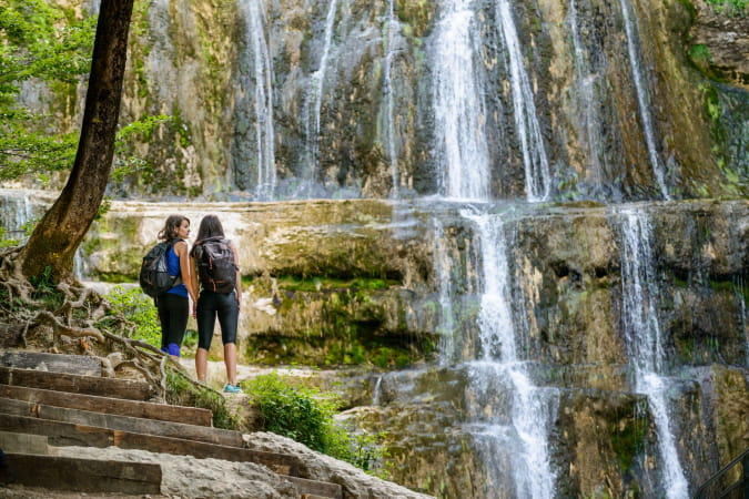 Amies en randonnée face aux cascades du Hérisson